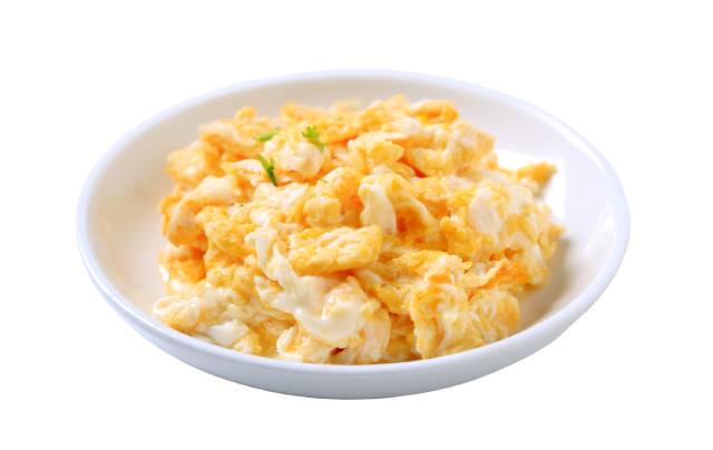 Scrambled eggs in a small white bowl.