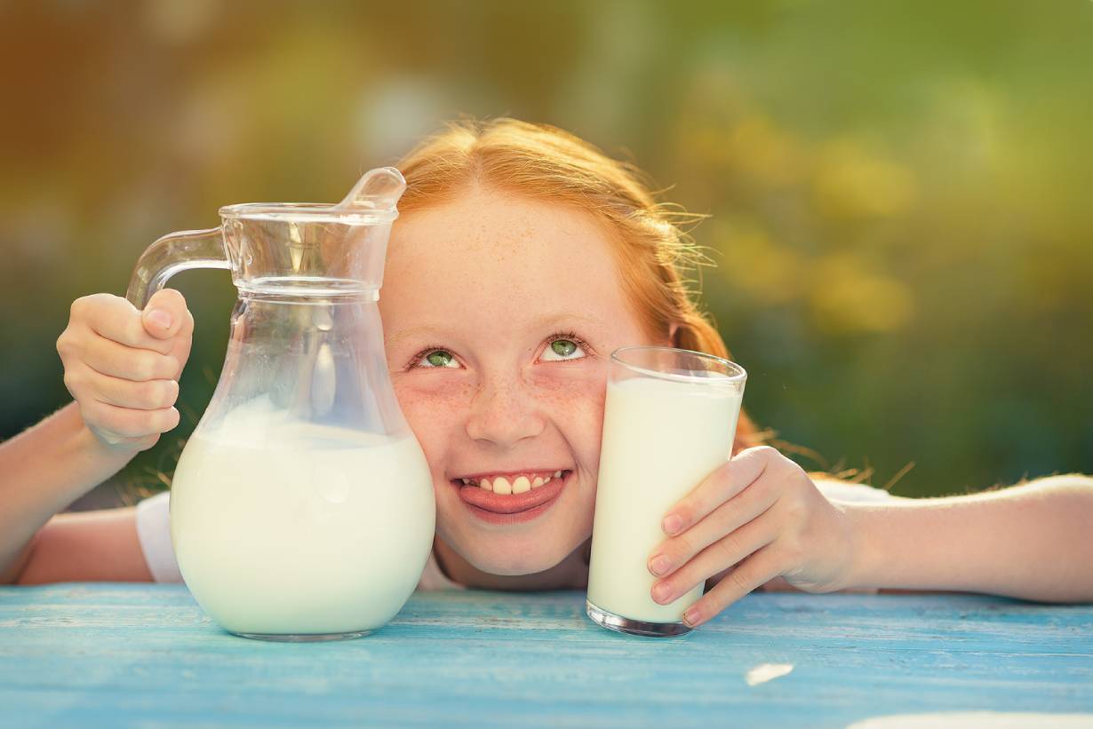 A Girl Holding a Jug and a Glass of Milk