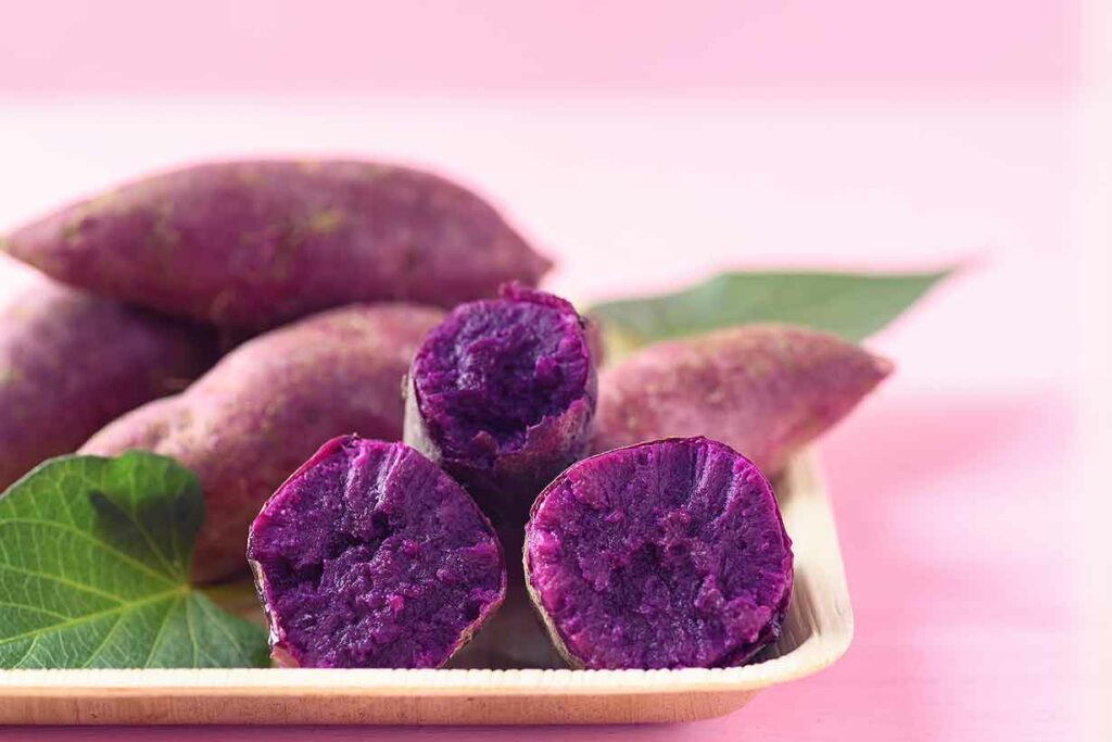 Purple Sweet Potatoes - Whole and Cut Open Showing Their Flesh.