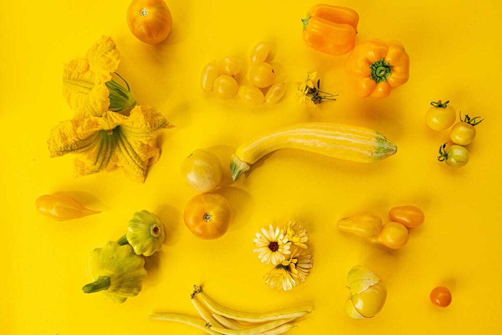 Various yellow vegetables on a yellow background.