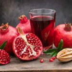 Whole and Half Pomegranates Showing Seeds, Next To Pomegranate Juice.