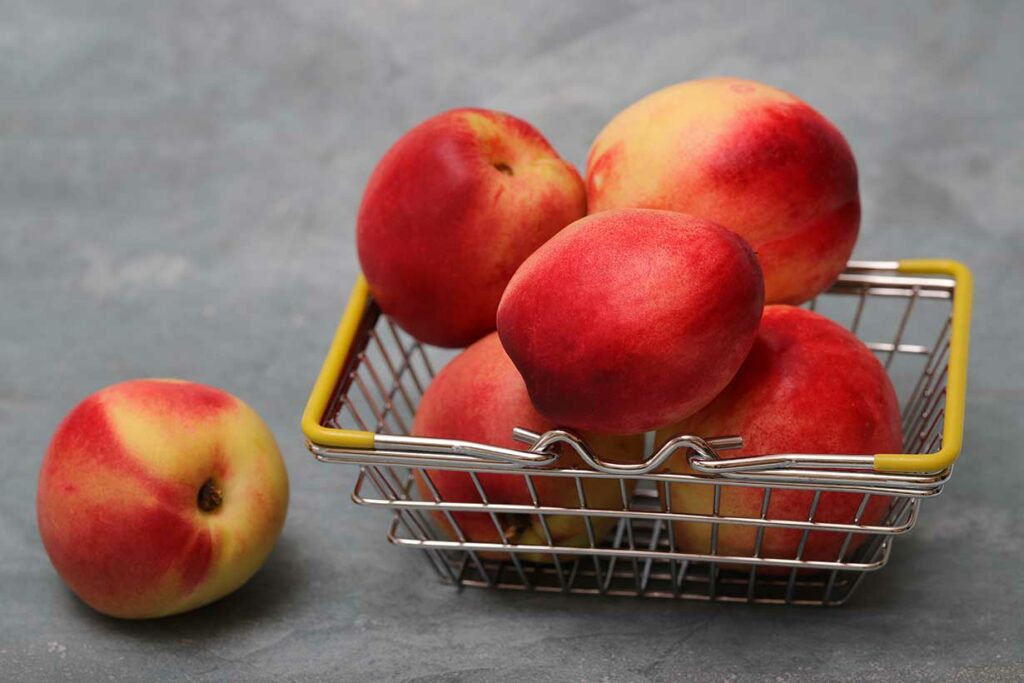 Five nectarines in a small basket.