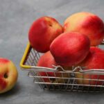Five nectarines in a small basket.