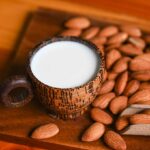 A Cup of Almond Milk Next To Almonds.