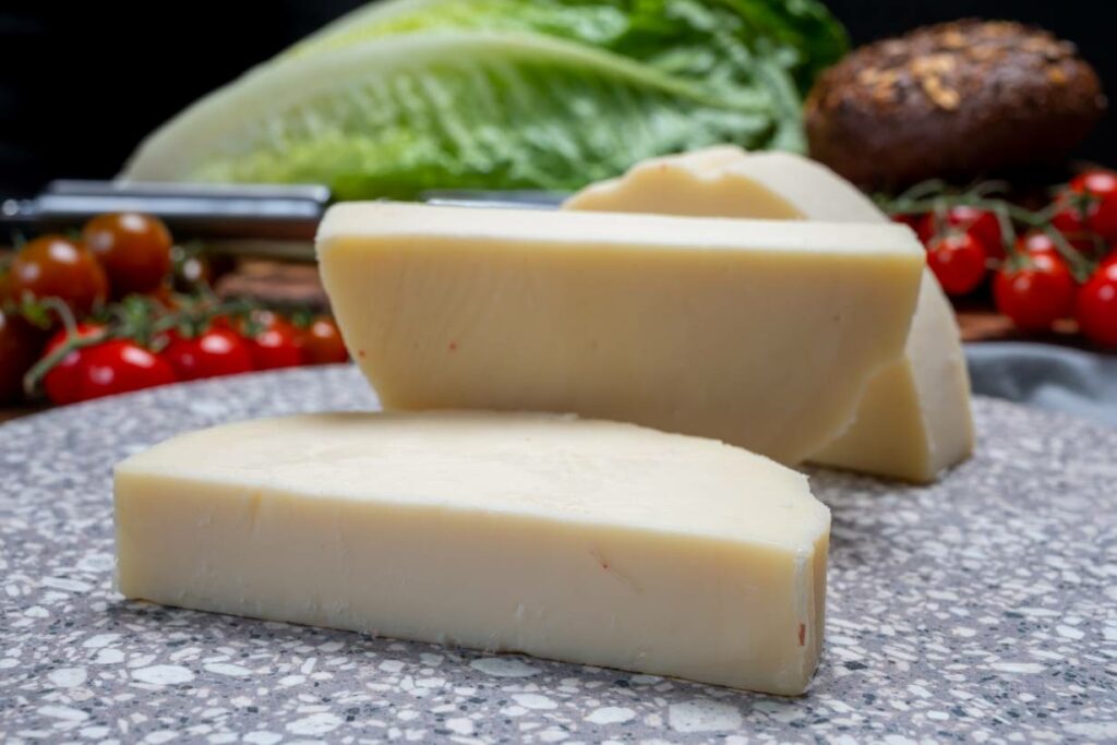 Large Wedges of Provolone Cheese On a Chopping Board.