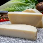 Large Wedges of Provolone Cheese On a Chopping Board.