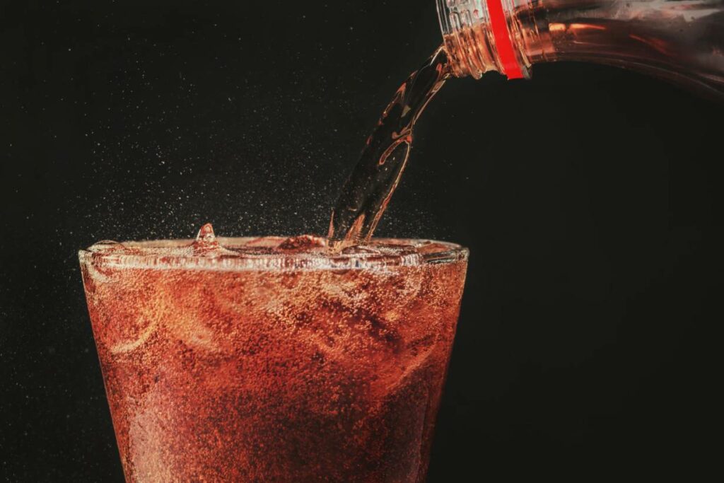 Cola Being Poured From a Bottle Into a Glass.