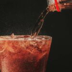 Cola Being Poured From a Bottle Into a Glass.