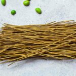 Edamame pasta spaghetti (dried) on a grey surface.