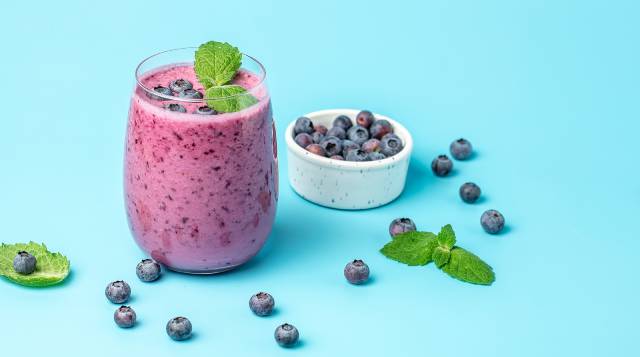 Bilberry yogurt next to a bowl of bilberries.