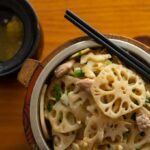 A dish in a pot containing lotus root slices, with chopsticks.