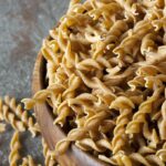 Dry Whole Wheat Pasta In a Wooden Bowl.