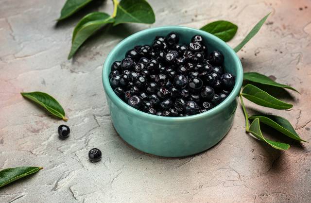 Maqui berries in a green bowl.