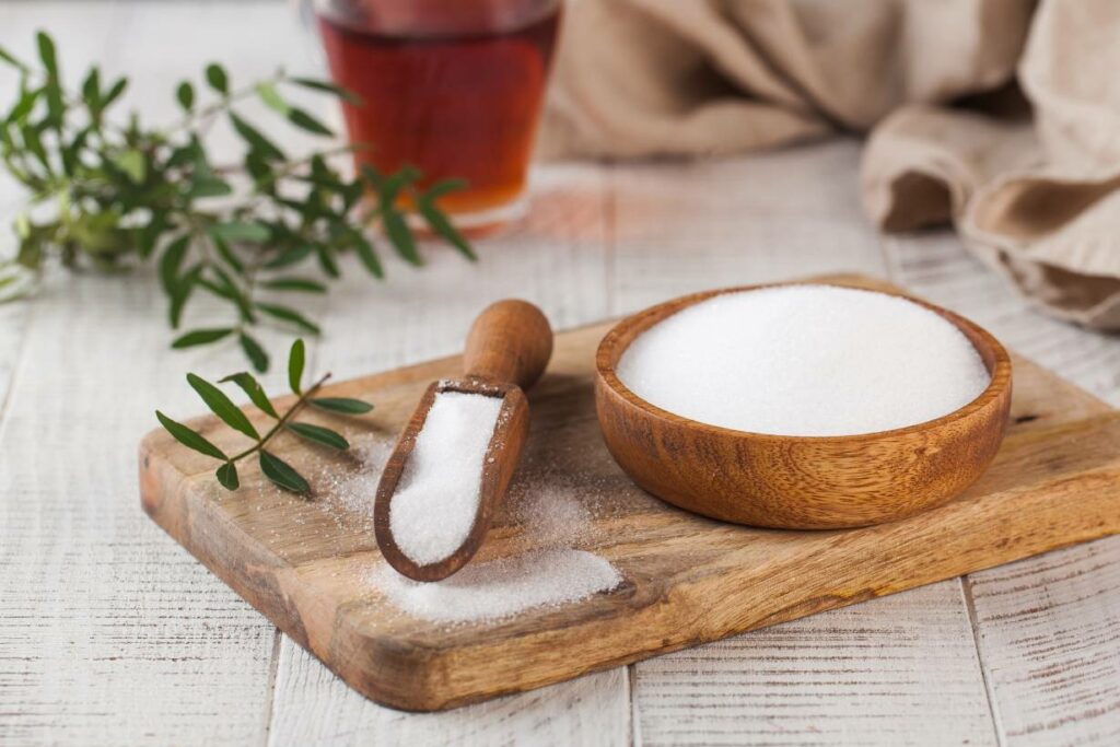 A powdered sweetener in a wooden bowl (erythritol/xylitol).