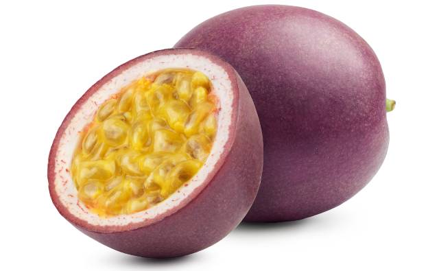 A whole purple passionfruit and one cut in half showing inner yellow flesh.