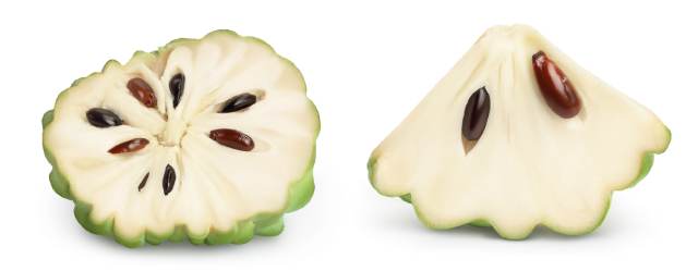 The inside flesh of cherimoya showing the dark seeds contained within.