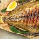 A cooked flounder fillet on a plate.