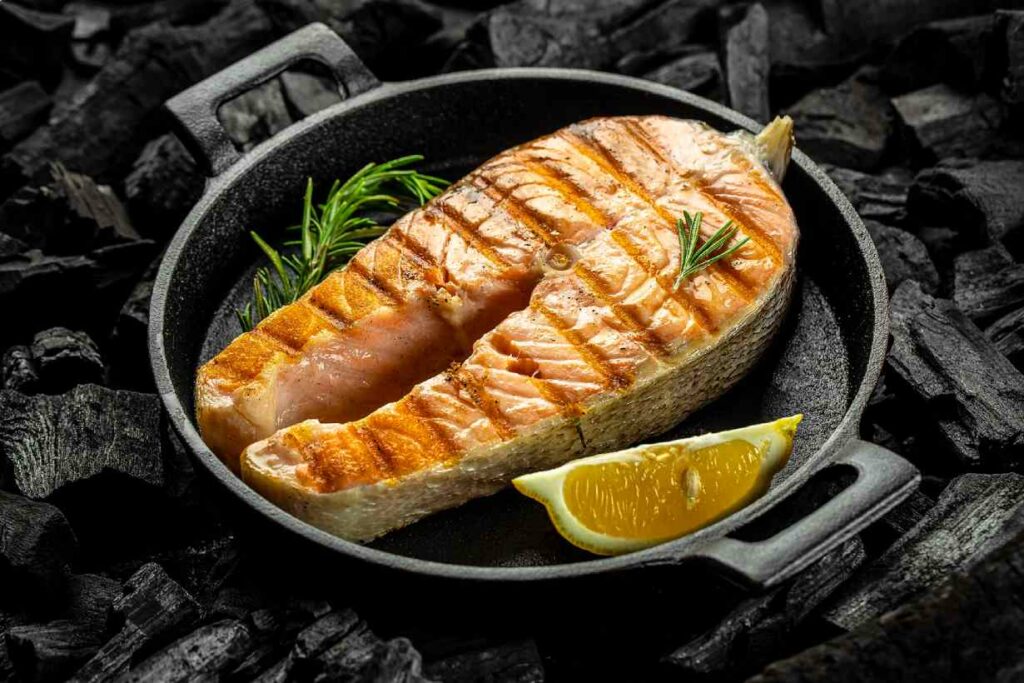 A cooked salmon fillet in a cast iron pan.