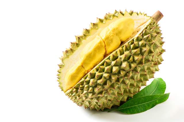 Durian fruit cut open showing inner yellow flesh.