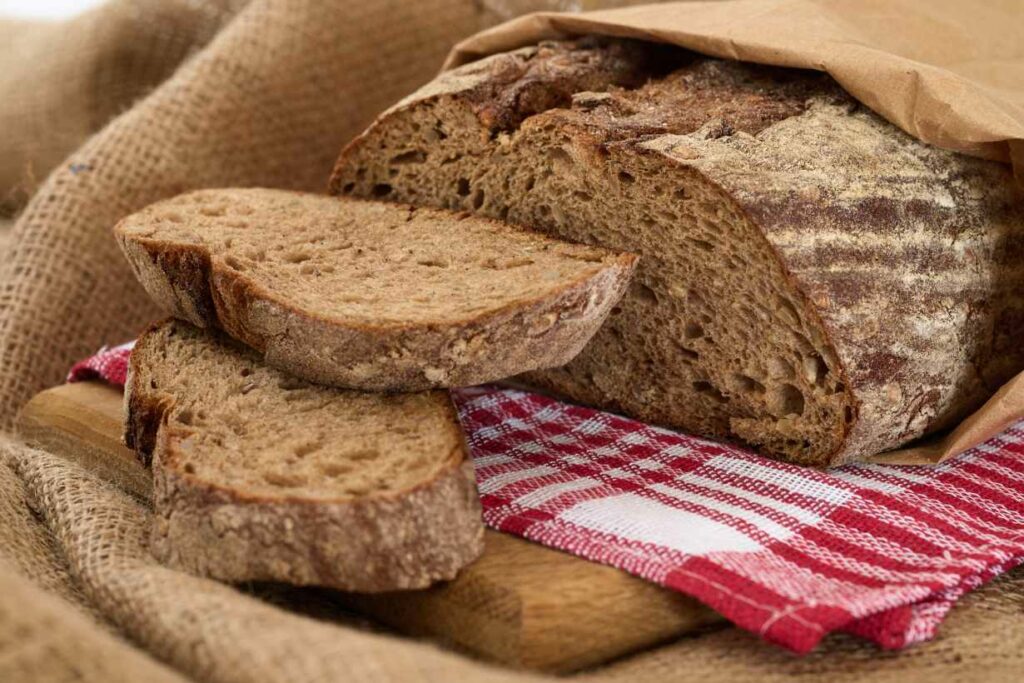 A loaf of rye bread with two slices cut off.