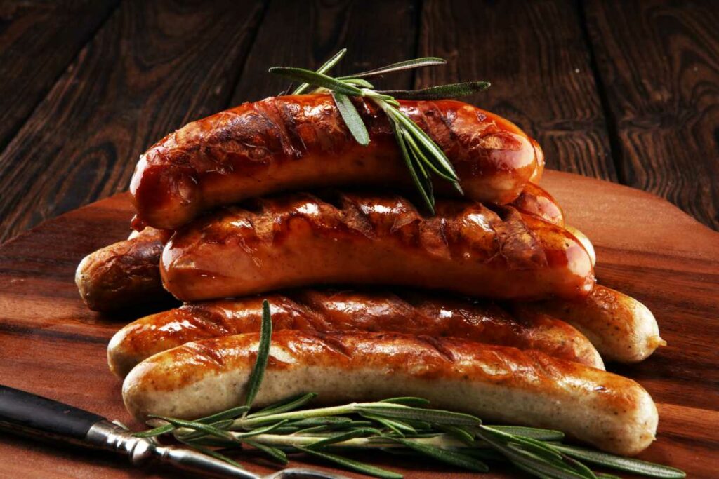 A pile of cooked sausages on a wooden surface.