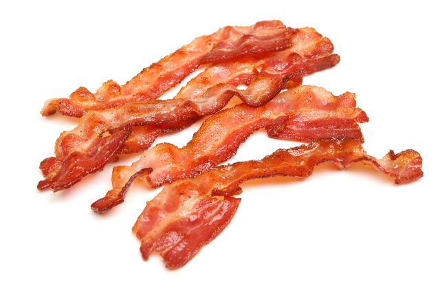 Slices of cooked traditional pork belly bacon.