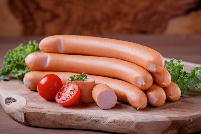 Vienna sausages on a wooden board.