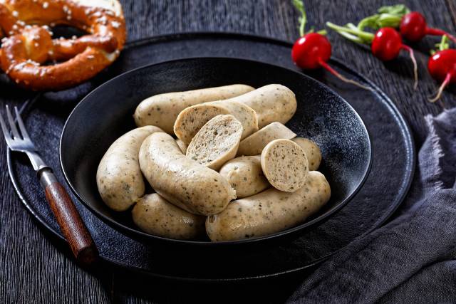 Weisswurst white sausages in a black bowl.