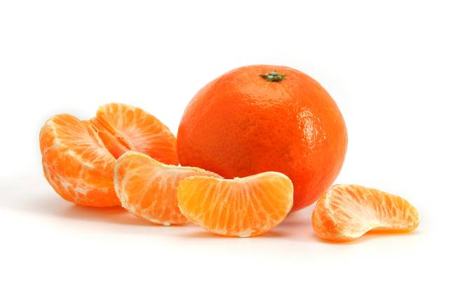 A whole and unpeeled satsuma next to peeled pieces.