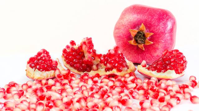 A cut pomegranate showing red seeds.