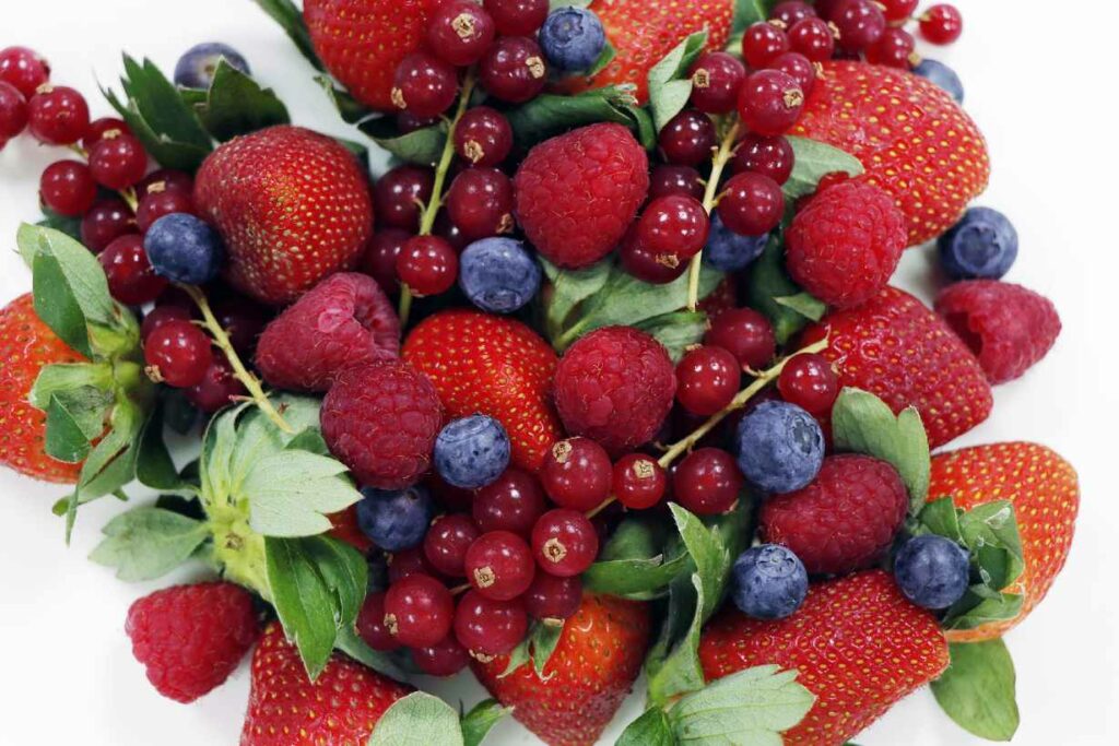 A variety of red fruits in a pile.