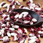 A pile of Anasazi beans on a wooden surface.