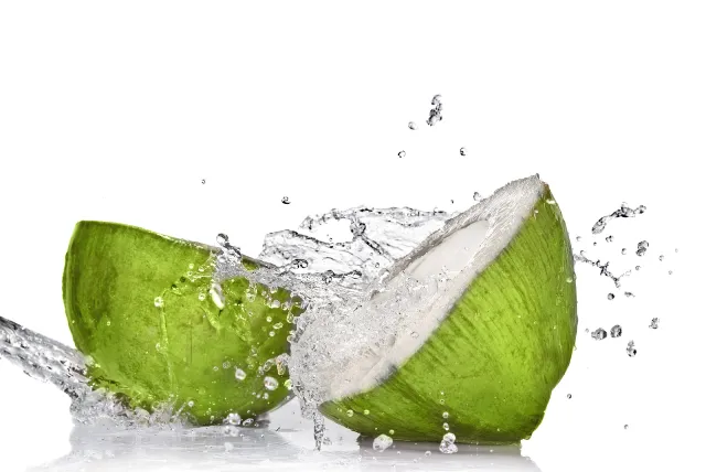 Coconut water coming out of a fresh green coconut.