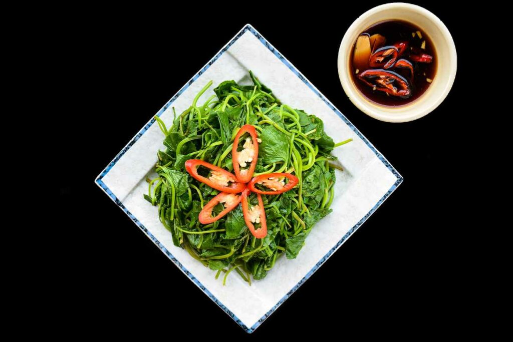 Stir-fried sweet potato leaves on a square-shaped plate.