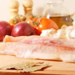 Raw swai fish fillet on a wooden board (Pangasius hypophthalmus).