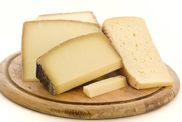 Pieces of Appenzeller cheese on a wooden board.