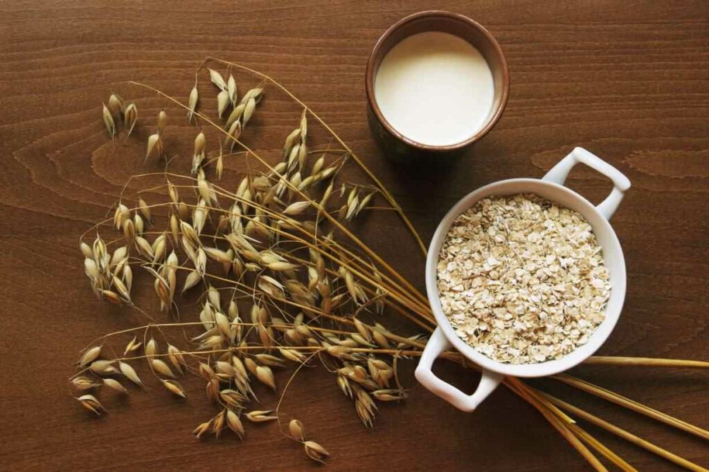 A cup of oat milk on a wooden surface.