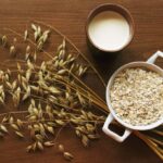 A cup of oat milk on a wooden surface.