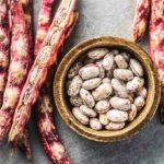 Raw borlotti beans in a wooden bowl.