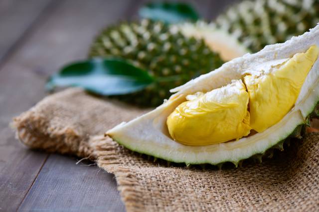 Durian fruit cut in half showing the inner flesh.