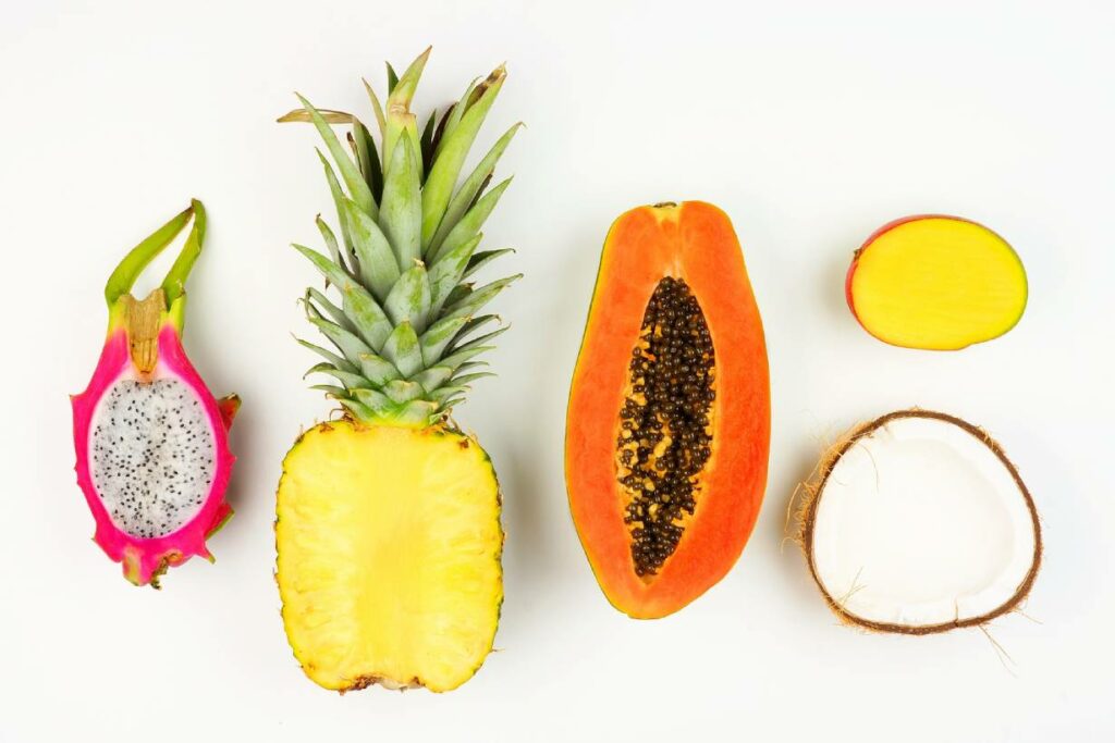 Various tropical fruits facing upward on a flat surface.