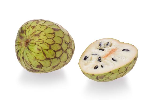 A whole and half cherimoya fruit.