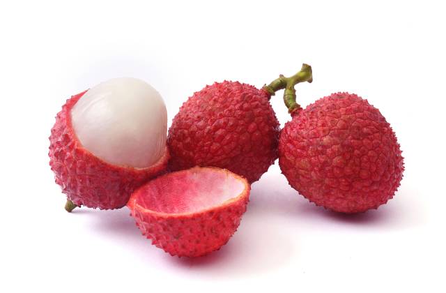 A whole lychee next to a peeled lychee showing its inner white flesh.
