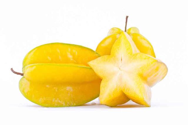 A whole star fruit next to a slice of the fruit.