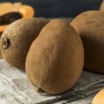 Whole and half pieces of mamey sapote fruit.