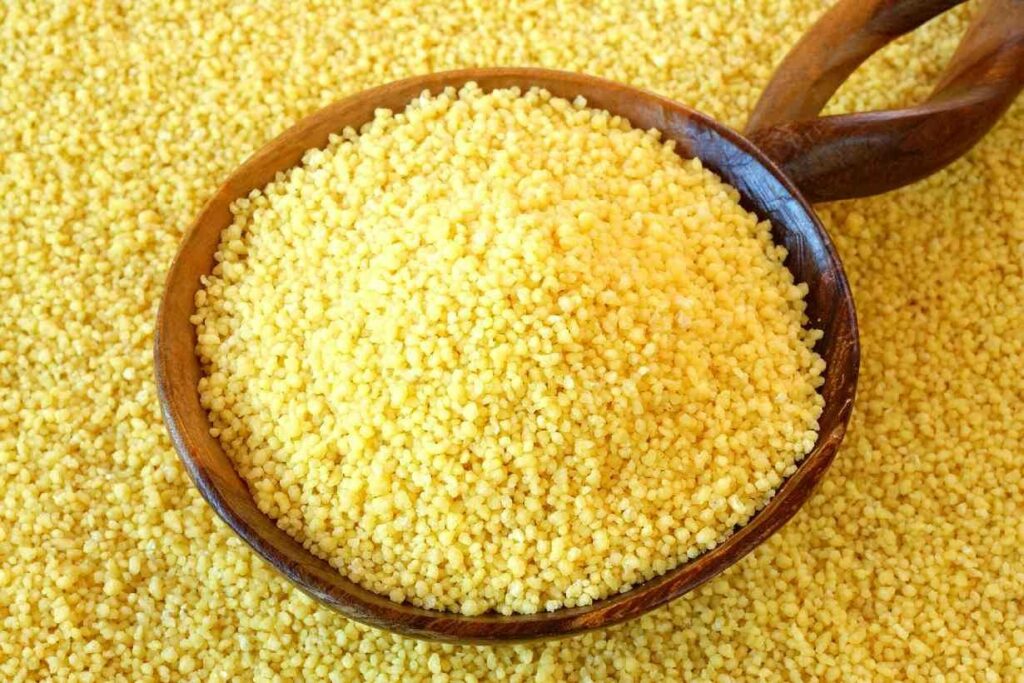 Couscous spilling out of a wooden bowl.