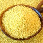 Couscous spilling out of a wooden bowl.