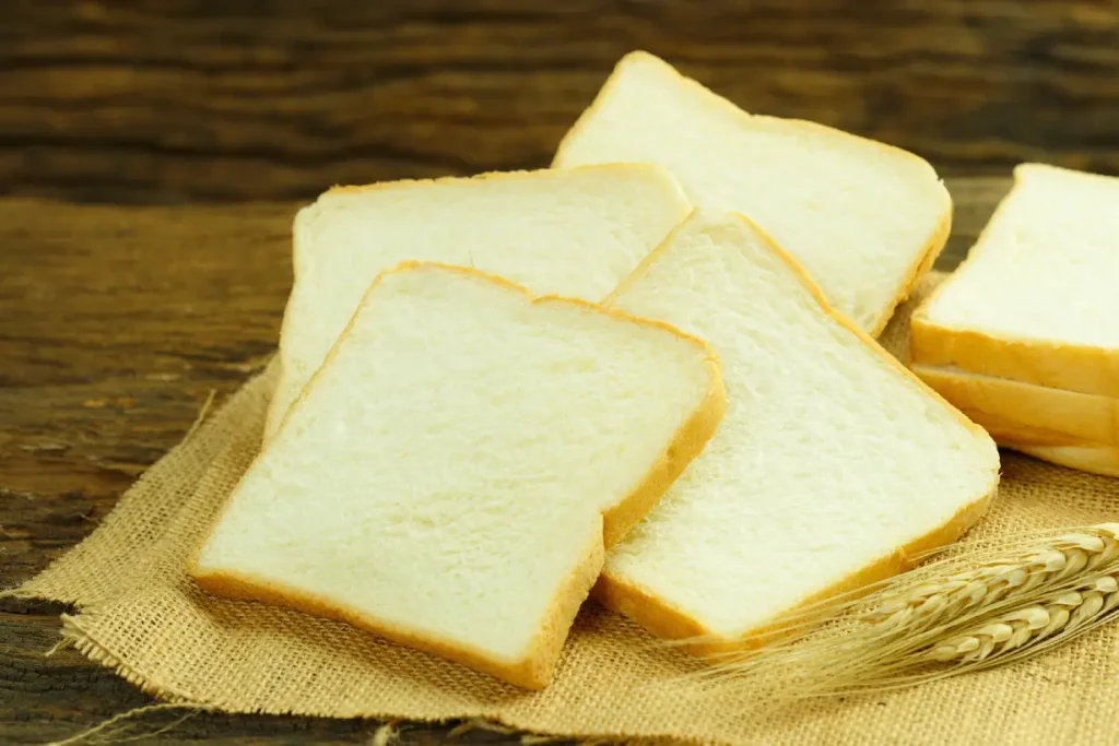 Slices of white bread on a wooden surface.