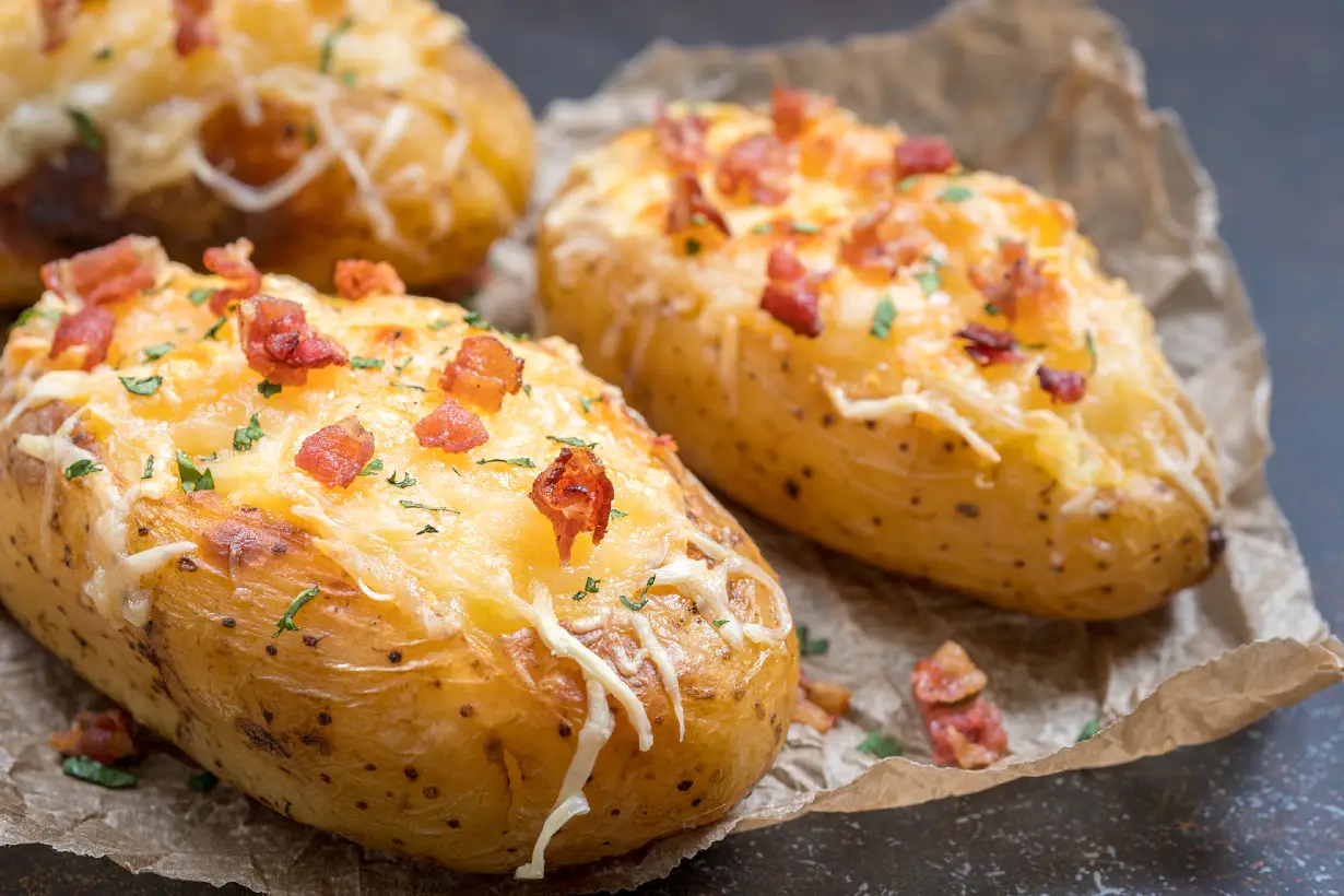 Baked potato topped with bacon, cheese, and sour cream.