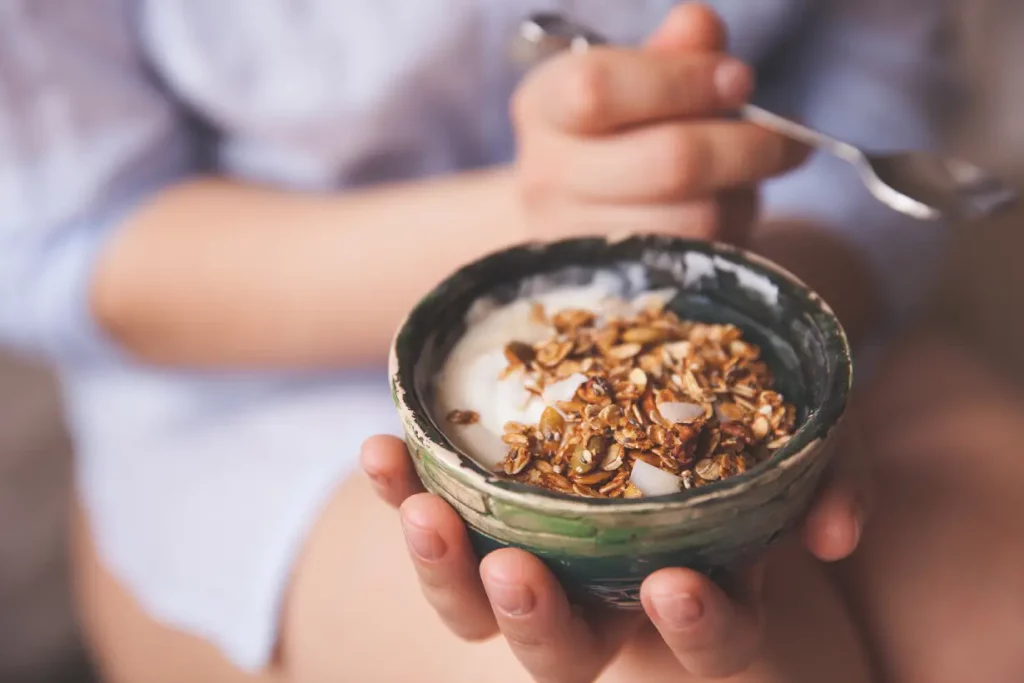 A person eating a healthy bowl of breakfast cereal.